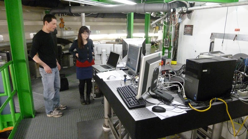 Kara Lamb, right, stands with a colleague next to the control system for the Chicago Water Isotope Spectrometer instrument at the Aerosol Interactions and Dynamics in the Atmosphere (AIDA) aerosol and cloud chamber at the Karlsruhe Institute of Technology in Germany